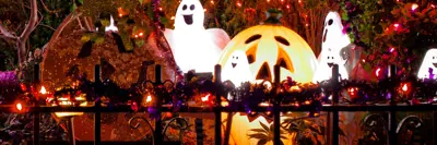 Jackolantern, ghosts and coloured lights decorate a front yard for Halloween