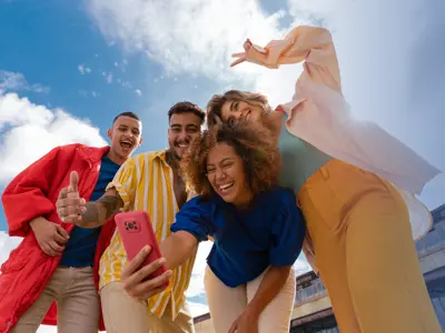 Group of young people taking a selfie against a blue sky